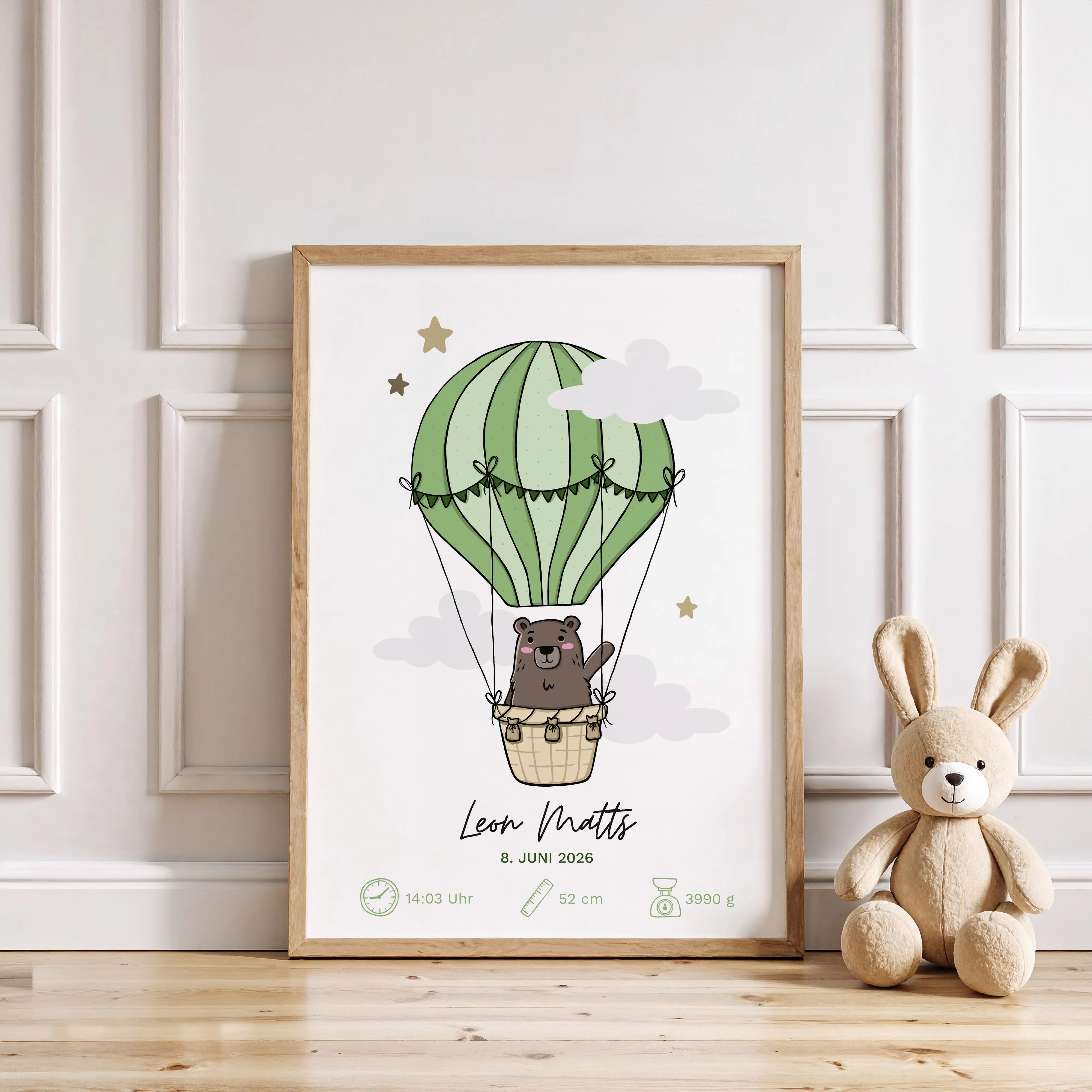 Geburtsposter Bär in grünem Heißluftballon darunter Kindername Geburtsdatum Uhrzeit Größe und Gewicht mit passenden Icons alles in einem Holzrahmen vor weißer Wand